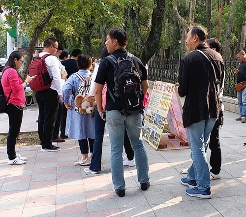 Китайські туристи вивчають матеріали Фалуньгун