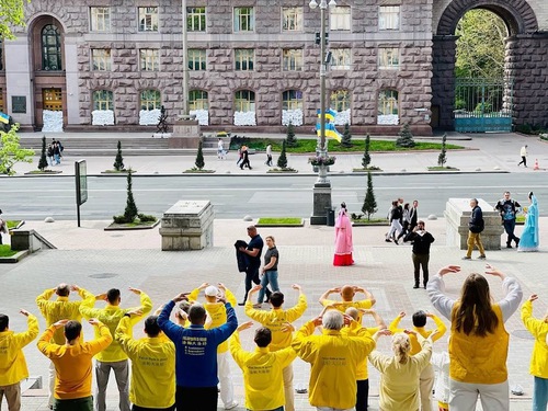 Практикувальники Фалуньгун демонструють вправи навпроти будівлі Київської міської ради