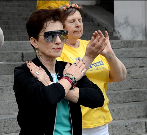 Наталя, яка приїхала зі зруйнованого війною Маріуполя, виконує вправи з практикувальниками Фалуньгун у Києві, 7 травня 2022 року