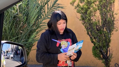 Перехожа дівчина читає буклет про Фалунь Дафа