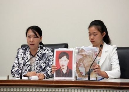 Сюй Сіньян (на цій фотографії їй 14 років) показує фото свого загиблого внаслідок переслідування батька Сюй Давея
