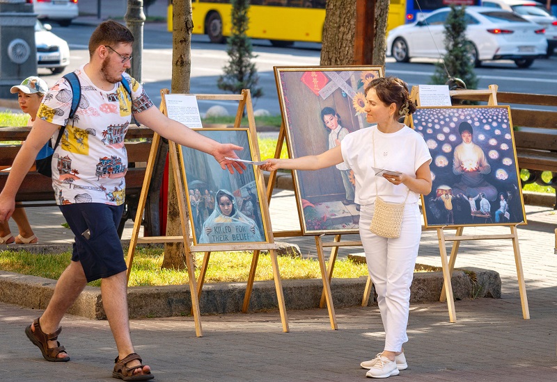 Перехожий приймає буклет від практикувальниці