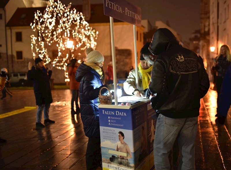 Практикувальники Фалунь Дафа розповідають людям про жорстоке переслідування в Китаї та збирають підписи під петицією під час заходу в Братиславі, 21 грудня 2025 року