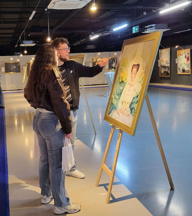 Відвідувачі розглядають картини на виставці «Мистецтво Чжень-Шань-Жень», яка проходила в Льєжі (Бельгія) з 12 грудня 2025 року до 11 січня 2026 року.